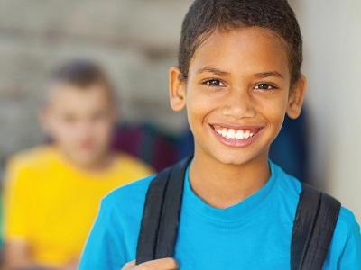 Child smiling after getting his braces off